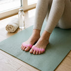 Écarteur d'orteils rose porté pendant des étirements sur un tapis
