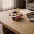 Velours Nomade branché, posé sur une table basse en chêne : le soin des pieds à la maison, en fin de journée